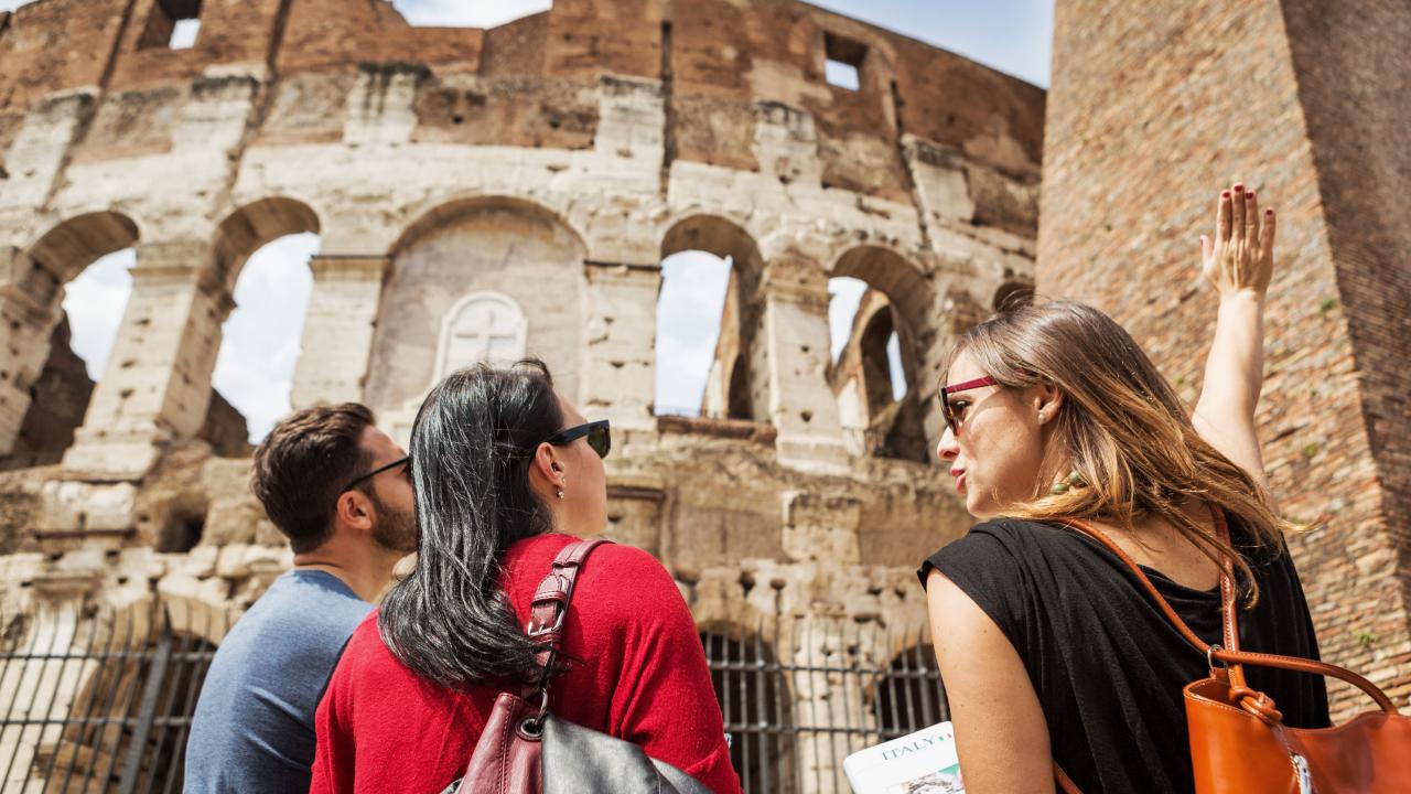 Guide explaining to tourists the Coliseum of Rome