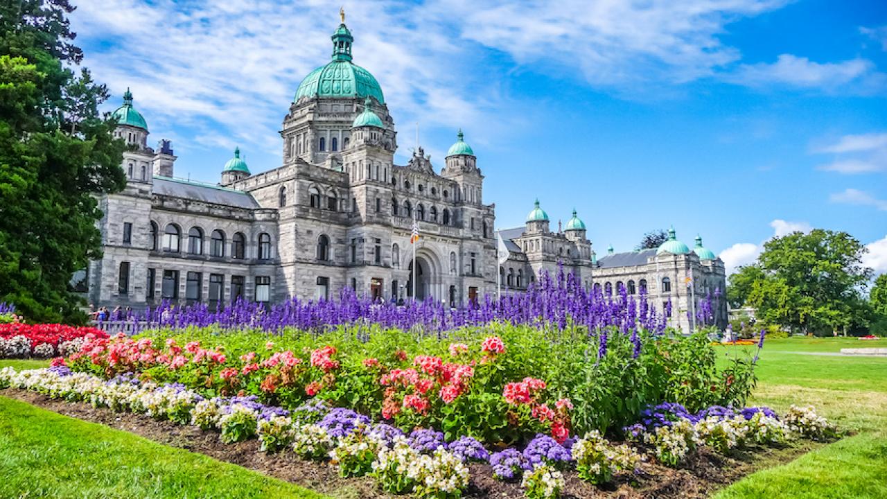 Historic parliament building in Victoria with colorful flowers, BC, Canada